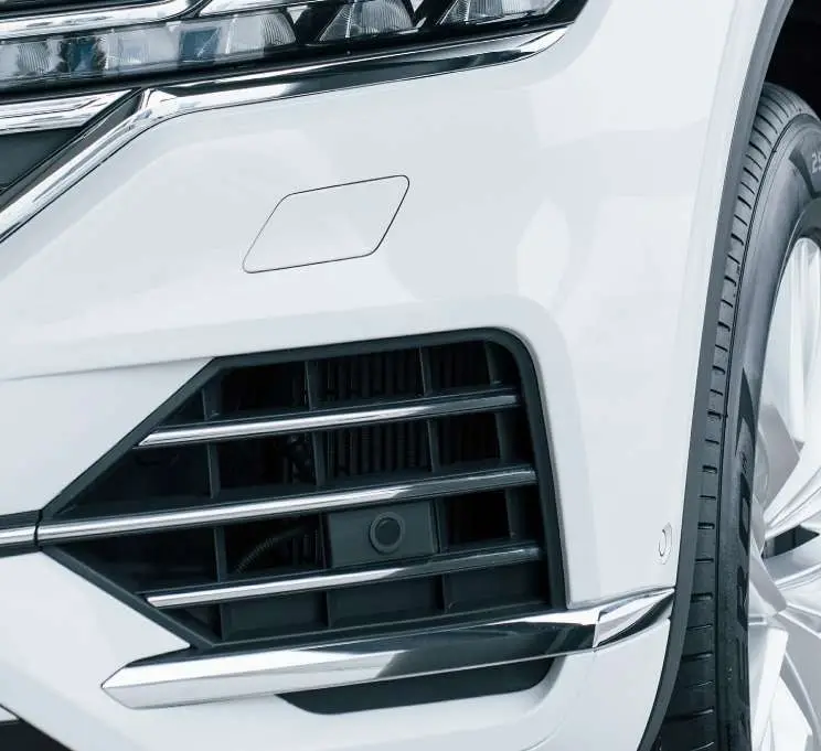 A scuffed white front bumper, after the repair