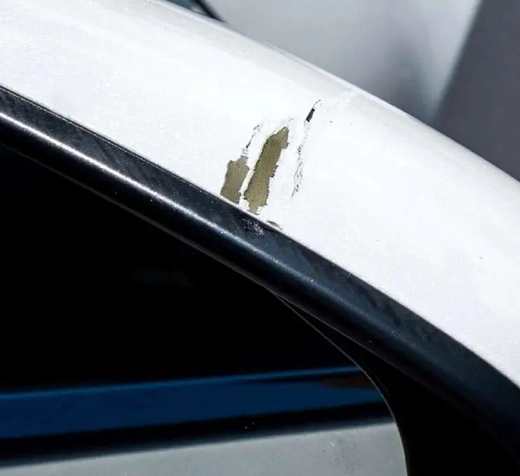A chipped white mirror casing, before the repair