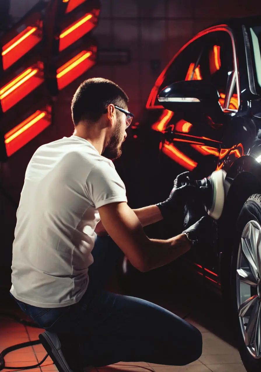 A technician polishing a repaired car door